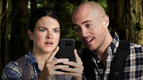 A man and woman looking at a cell phone.