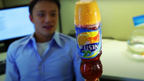 A man sitting in front of an orange juice bottle.