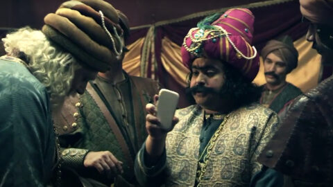 A man in a turban is looking at his phone.