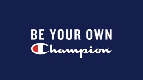 Logo with the text "be your own champion" in white letters featuring the champion brand logo, set against a blue background.